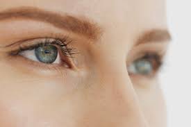 This image shows a close up view of a woman's eyes. She is looking confidentially into the distance. One eye is blurred, suggesting trouble with her vision.